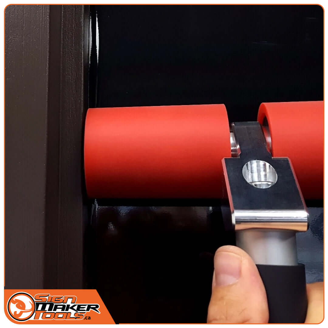 Double roller tool applying vinyl right up to the edge of a dark frame