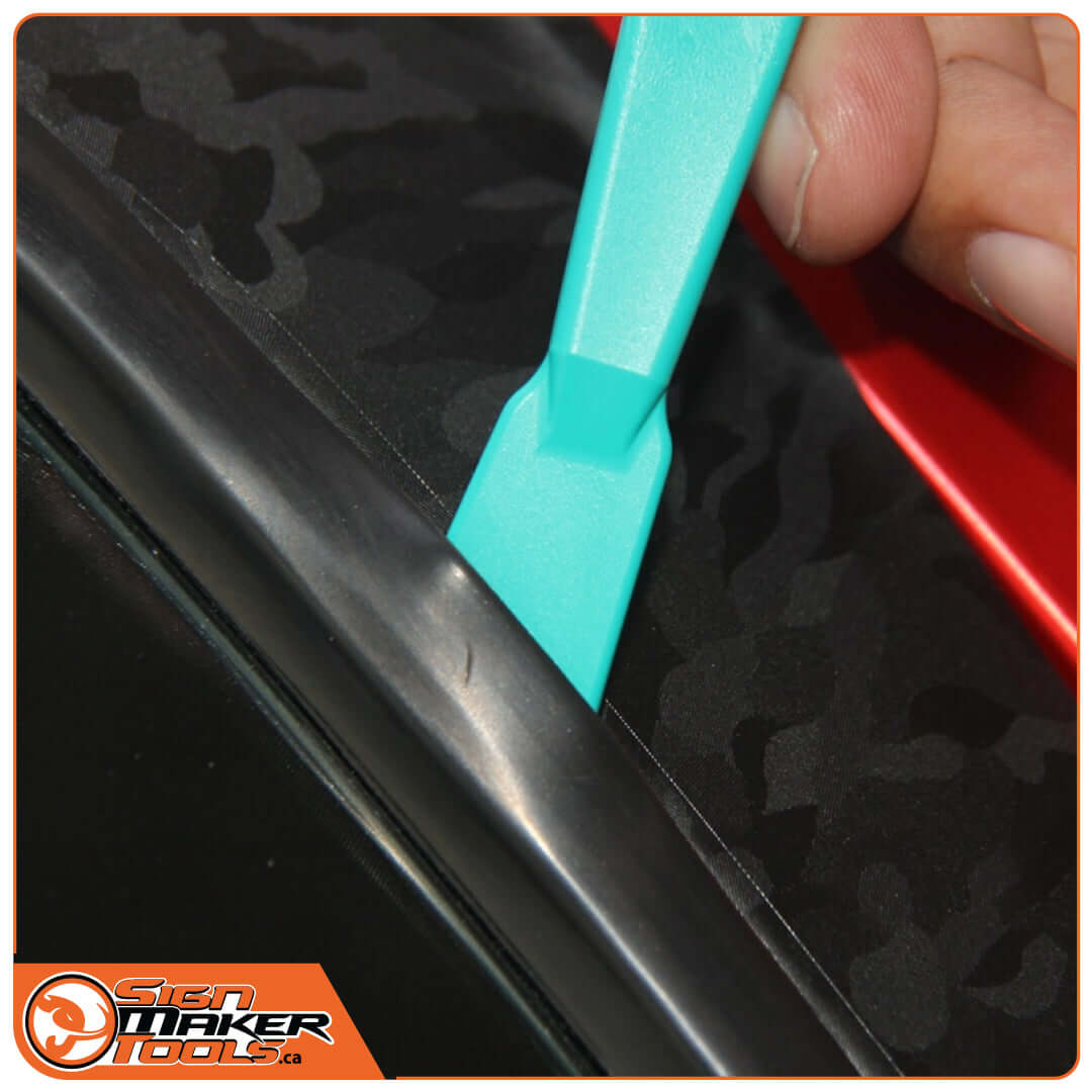 WrapStick Sloan tool reaching deep into car trim corner during vinyl wrap application
