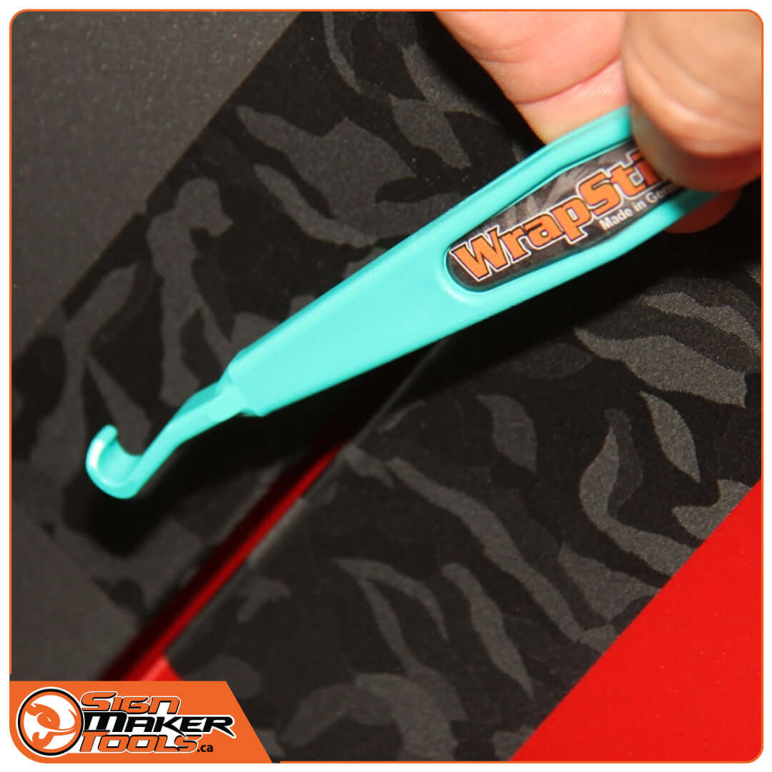 Using the WrapStick Hook to tuck vinyl into a tight car body seam
